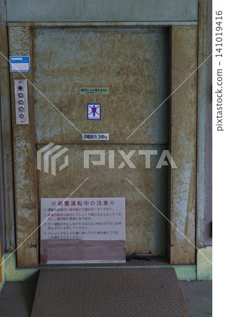 An old freight elevator with a "No Pedestrians" sign posted on it. An old freight elevator with a "No Pedestrians" sign posted on it. 141019416