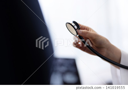 Close-up of a stethoscope held by a female doctor. Close-up of a stethoscope held by a female doctor. 141019555