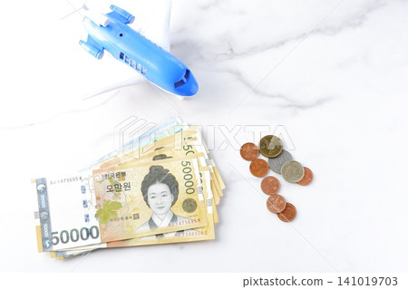 Image of departing for a trip to Korea with Korean won (KRW) banknotes and an airplane Image of departing for a trip to Korea with Korean won (KRW) banknotes and an airplane 141019703