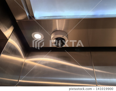 Dome security surveillance camera mounted on stainless steel elevator ceiling Dome security surveillance camera mounted on stainless steel elevator ceiling 141019900