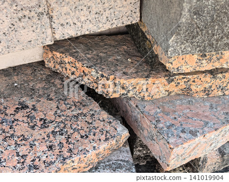 Red and pink granite slabs stacked close up with speckled texture Red and pink granite slabs stacked close up with speckled texture 141019904