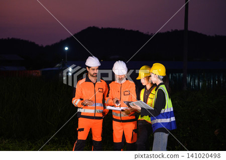 Four engineers discussing inspection work outside oil refinery and petrochemical processing facility Four engineers discussing inspection work outside oil refinery and petrochemical processing facility 141020498