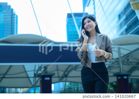 Businesswoman talking on smartphone in business district Businesswoman talking on smartphone in business district 141020667