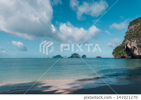 Beautiful view of a limestone karst island from a sandy beach under an overhanging cliff in Krabi, Thailand. 141021270