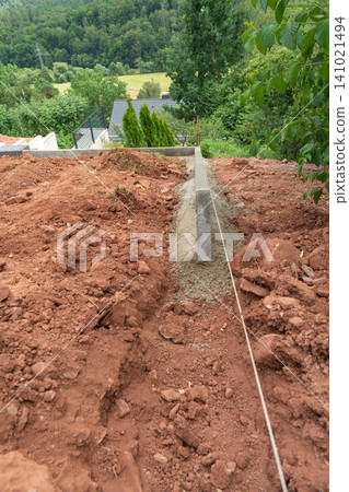an outdoor construction site where excavation is in progress, showcasing a ground-level view of excavated soil, concrete blocks, and metal rods, with a neutral mood and brown and gray tones. an outdoor construction site where excavation is in progress, showcasing a ground-level view of excavated soil, concrete blocks, and metal rods, with a neutral mood and brown and gray tones. 141021494