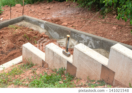 construction progress of concrete blocks at outdoor site with hammer and metal tools, top-down view, work in progress, gray brown green colors, natural light, clean background, suitable. construction progress of concrete blocks at outdoor site with hammer and metal tools, top-down view, work in progress, gray brown green colors, natural light, clean background, suitable. 141021548