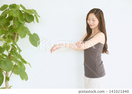 年輕女性的護膚流程：觸摸並檢查手臂上的皮膚。 141021840