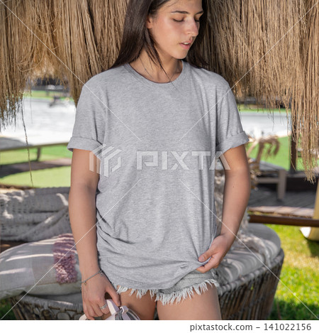 Blank heather grey shirt mockup, young woman outdoors on a sunny day, front view with copy space Blank heather grey shirt mockup, young woman outdoors on a sunny day, front view with copy space 141022156