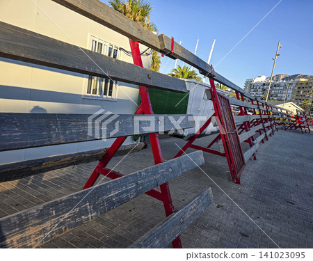 Barricades made of wood and metal are set up in a street in Spain for the encierro festival. This event involves running with bulls and draws many spectators each year. Barricades made of wood and metal are set up in a street in Spain for the encierro festival. This event involves running with bulls and draws many spectators each year. 141023095
