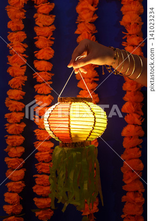 Hand holding traditional paper lantern for Diwali festival celebration Hand holding traditional paper lantern for Diwali festival celebration 141023234