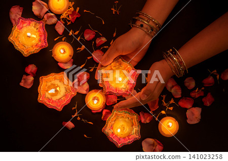 Hands holding lit clay diya lamp for Diwali festival celebration Hands holding lit clay diya lamp for Diwali festival celebration 141023258