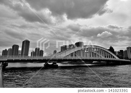 A view of the tower apartment buildings in Tsukuda, Chuo Ward, across the Eitai Bridge from the Sumida River Terrace. Rain clouds. Monochrome. A view of the tower apartment buildings in Tsukuda, Chuo Ward, across the Eitai Bridge from the Sumida River Terrace. Rain clouds. Monochrome. 141023391