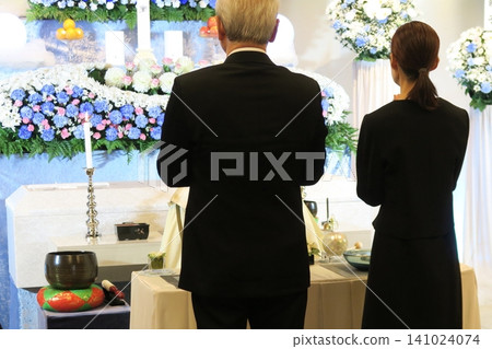 Relatives clasp their hands together in prayer towards the altar. Relatives clasp their hands together in prayer towards the altar. 141024074