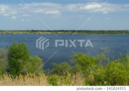 A peaceful view of the Volga River with lush green treeas under a clear blue sky. A peaceful view of the Volga River with lush green treeas under a clear blue sky. 141024351