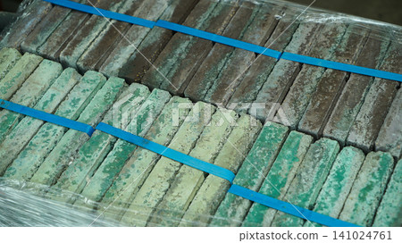 Palletized green and brown clay bricks wrapped in plastic film Palletized green and brown clay bricks wrapped in plastic film 141024761