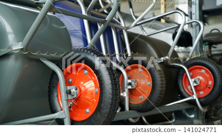 Row of industrial wheelbarrows on a display rack at a hardware store Row of industrial wheelbarrows on a display rack at a hardware store 141024771