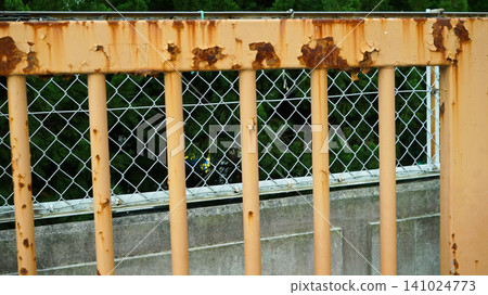Rusty old iron railing with peeling beige paint Rusty old iron railing with peeling beige paint 141024773