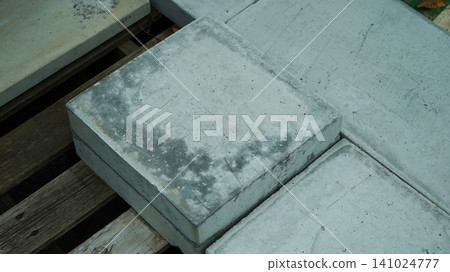Square concrete paving slab on a wooden pallet close up Square concrete paving slab on a wooden pallet close up 141024777
