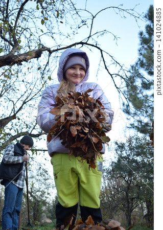 Young father, pre-teen daughter and son in warm autumn clothes spending quality time together among fallen leaves. Happy family enjoying the beauty of fall, playful moments and family life outdoors Young father, pre-teen daughter and son in warm autumn clothes spending quality time together among fallen leaves. Happy family enjoying the beauty of fall, playful moments and family life outdoors 141024885