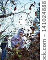 Young father, pre-teen daughter and son in warm autumn clothes spending quality time together among fallen leaves. Happy family enjoying the beauty of fall, playful moments and family life outdoors 141024888