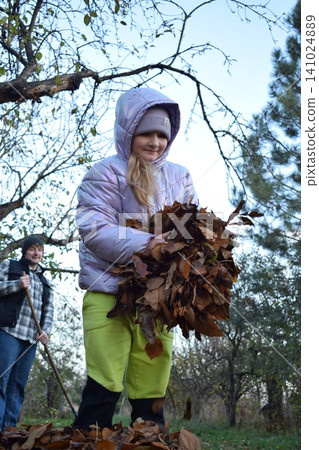 Young father, pre-teen daughter and son in warm autumn clothes spending quality time together among fallen leaves. Happy family enjoying the beauty of fall, playful moments and family life outdoors Young father, pre-teen daughter and son in warm autumn clothes spending quality time together among fallen leaves. Happy family enjoying the beauty of fall, playful moments and family life outdoors 141024889