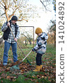 Young father, pre-teen daughter and son in warm autumn clothes spending quality time together among fallen leaves. Happy family enjoying the beauty of fall, playful moments and family life outdoors 141024892