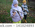 Young father, pre-teen daughter and son in warm autumn clothes spending quality time together among fallen leaves. Happy family enjoying the beauty of fall, playful moments and family life outdoors 141024893