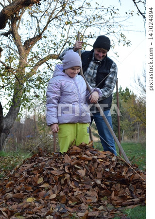 Young father, pre-teen daughter and son in warm autumn clothes spending quality time together among fallen leaves. Happy family enjoying the beauty of fall, playful moments and family life outdoors Young father, pre-teen daughter and son in warm autumn clothes spending quality time together among fallen leaves. Happy family enjoying the beauty of fall, playful moments and family life outdoors 141024894