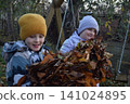 Young father, pre-teen daughter and son in warm autumn clothes spending quality time together among fallen leaves. Happy family enjoying the beauty of fall, playful moments and family life outdoors 141024895