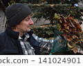 Young father, pre-teen daughter and son in warm autumn clothes spending quality time together among fallen leaves. Happy family enjoying the beauty of fall, playful moments and family life outdoors 141024901