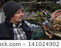 Young father, pre-teen daughter and son in warm autumn clothes spending quality time together among fallen leaves. Happy family enjoying the beauty of fall, playful moments and family life outdoors 141024902