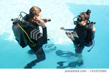 Professional scuba diver instructs the novice how to use the equipment before dive Professional scuba diver instructs the novice how to use the equipment before dive 141025080