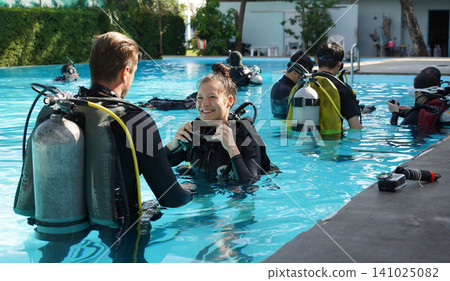 Professional scuba diver instructs the novice how to use the equipment before dive Professional scuba diver instructs the novice how to use the equipment before dive 141025082