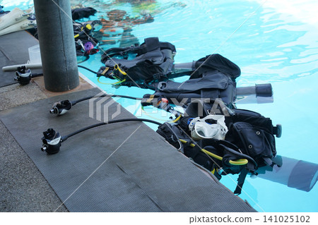 Scuba diving equipment with oxygen tank near swimming pool 141025102