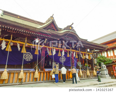 The main hall of Yasaka Shrine, located next to Kokura Castle in Kitakyushu City, and a person praying there. The main hall of Yasaka Shrine, located next to Kokura Castle in Kitakyushu City, and a person praying there. 141025167