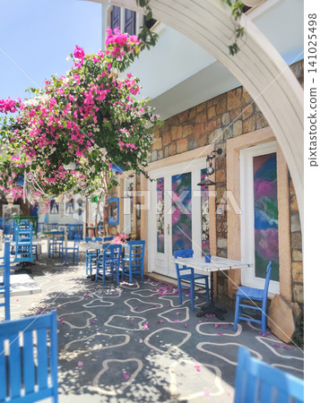 Mediterranean street cafe with blue chairs and bougainvillea in Kas Turkey 141025498