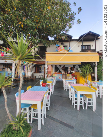 Empty outdoor cafe with colorful tables at dusk in Kas Turkey Empty outdoor cafe with colorful tables at dusk in Kas Turkey 141025502