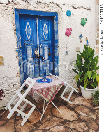 Rustic blue wooden door with decorative fish and street cafe in Kalkan Turkey Rustic blue wooden door with decorative fish and street cafe in Kalkan Turkey 141025518