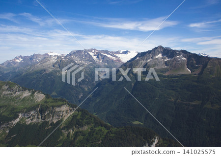 Rugged alpine peaks and mountain ranges under a cloudy sky 141025575