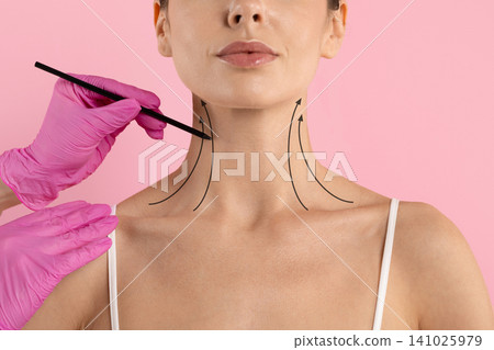 Womans neck marked with upward arrows by gloved hand holding pencil Womans neck marked with upward arrows by gloved hand holding pencil 141025979