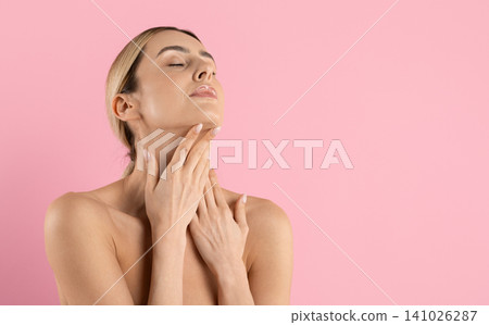 Young woman with closed eyes touching neck and chin, head tilted back Young woman with closed eyes touching neck and chin, head tilted back 141026287
