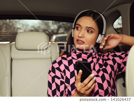 Young woman listening to audiobook in car Young woman listening to audiobook in car 141026437