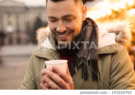Happy man with mulled wine at winter fair Happy man with mulled wine at winter fair 141026763