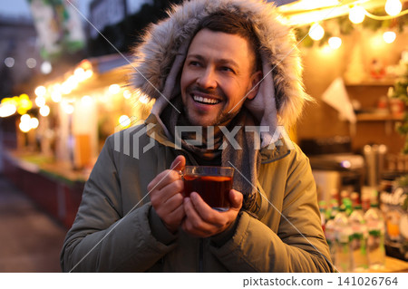 Happy man with mulled wine at winter fair 141026764