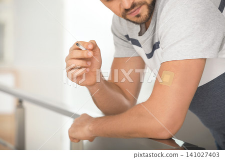 Man with nicotine patch and cigarette indoors, closeup 141027403