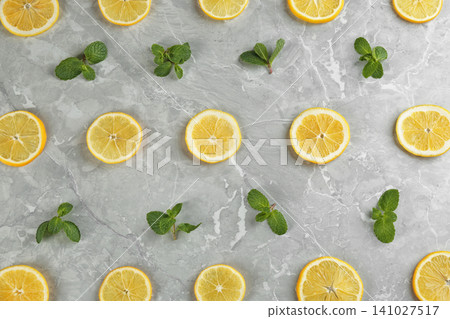 Lemonade layout with juicy lemon slices and mint on grey marble table, top view Lemonade layout with juicy lemon slices and mint on grey marble table, top view 141027517