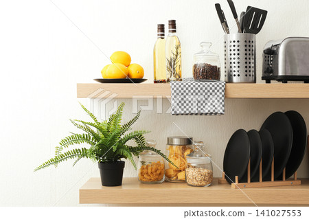 Wooden shelves with dishware and products on white wall. Kitchen interior idea Wooden shelves with dishware and products on white wall. Kitchen interior idea 141027553