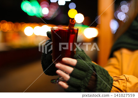 Woman with tasty mulled wine at winter fair, closeup 141027559