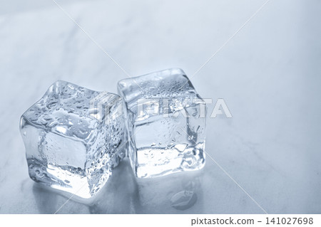 Crystal clear ice cubes with water drops on light table, closeup 141027698