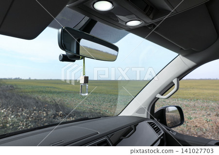 Air freshener hanging on rear view mirror in car Air freshener hanging on rear view mirror in car 141027703